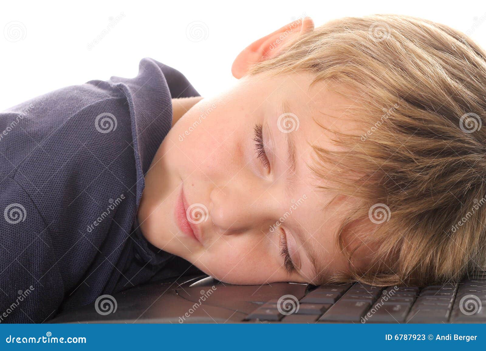 Niño pequeño dormido en el ordenador aislado en blanco