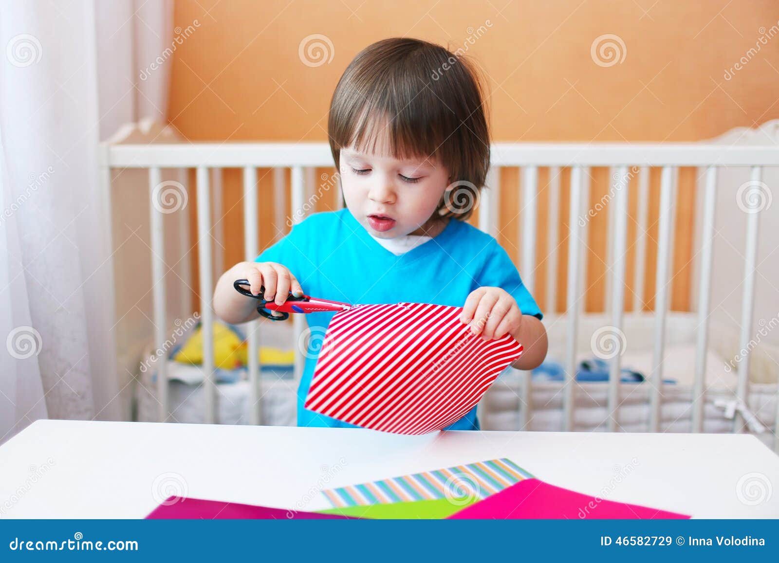 Niño Pequeño Precioso Con Las Tijeras Que Cortan El Papel Imagen De