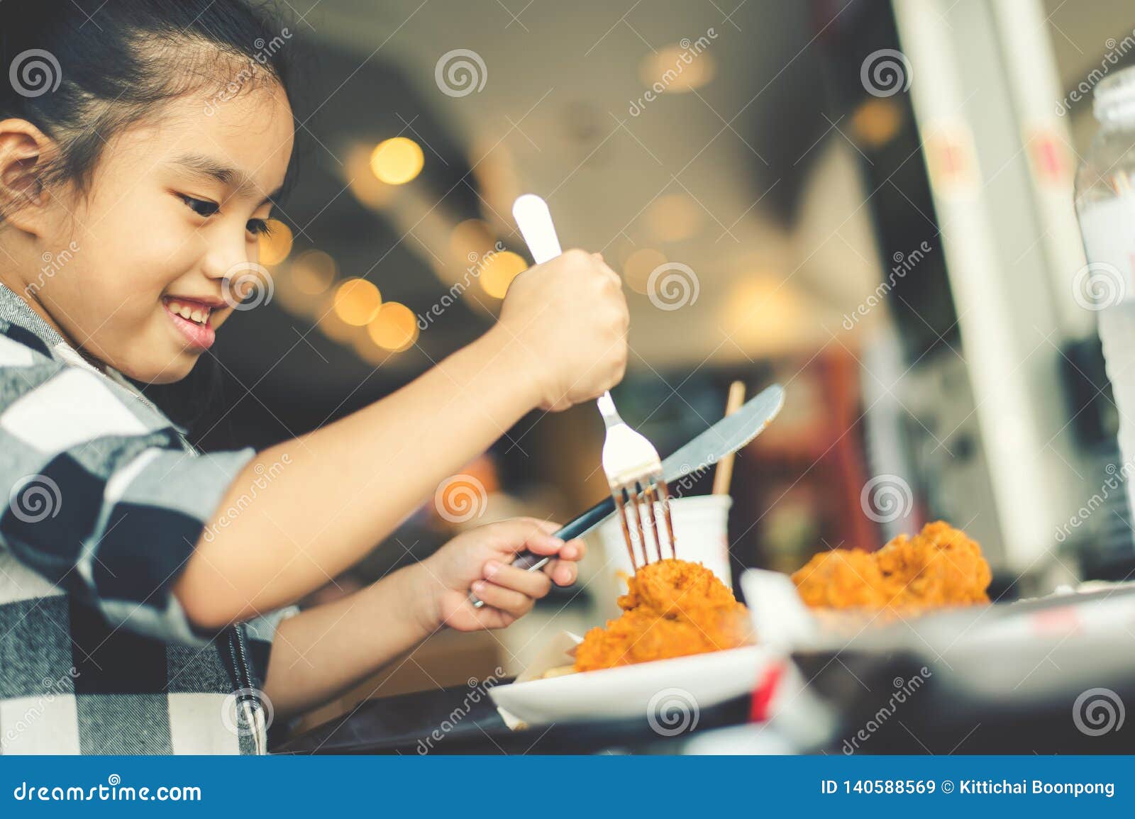 Niños asiáticos que comen a Fried Chicken Food Court