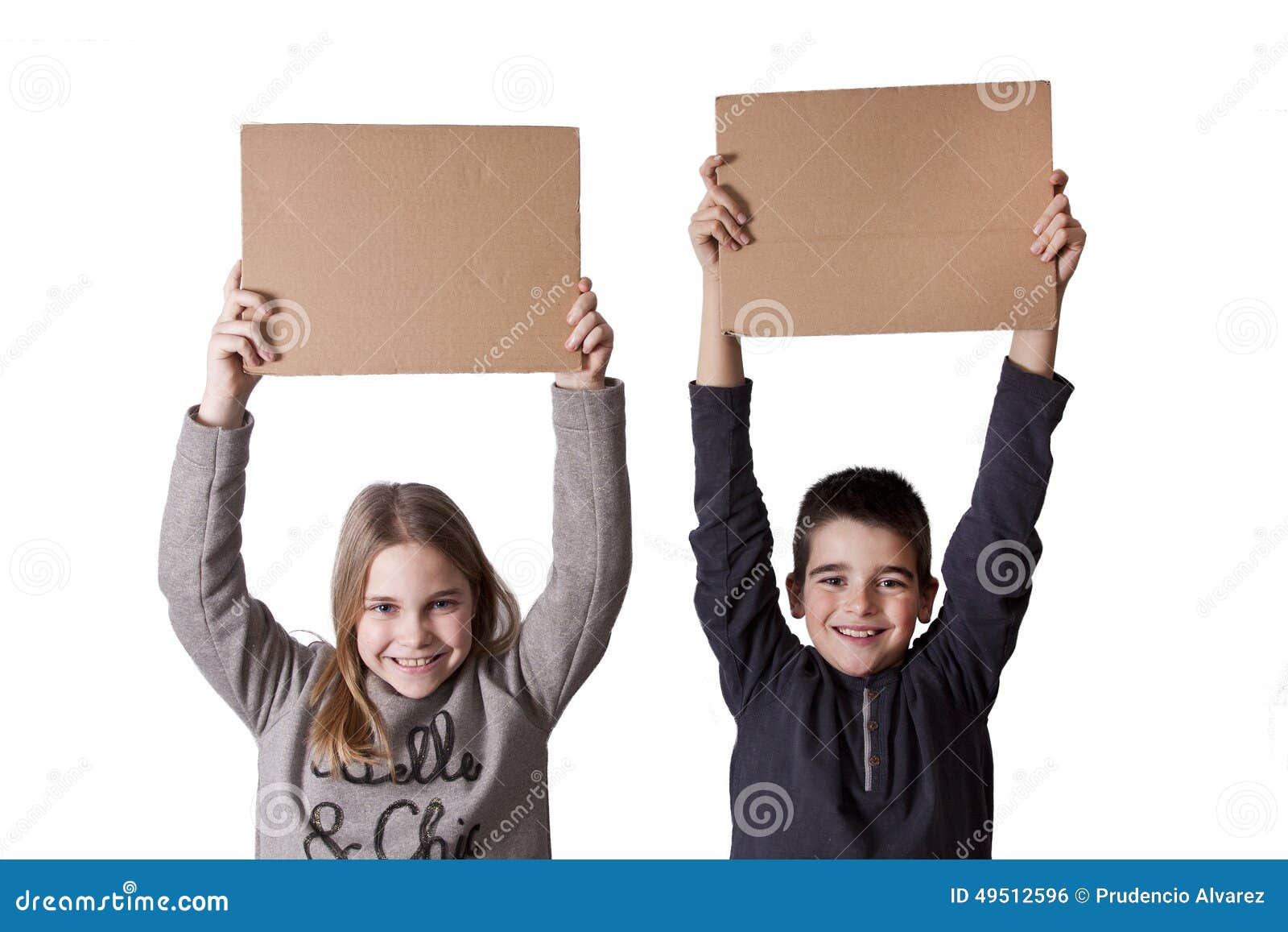 Niños con las muestras de la cartulina. Pares de muchacho y de muchacha que llevan a cabo al tablero con el espacio para el texto y los anuncios