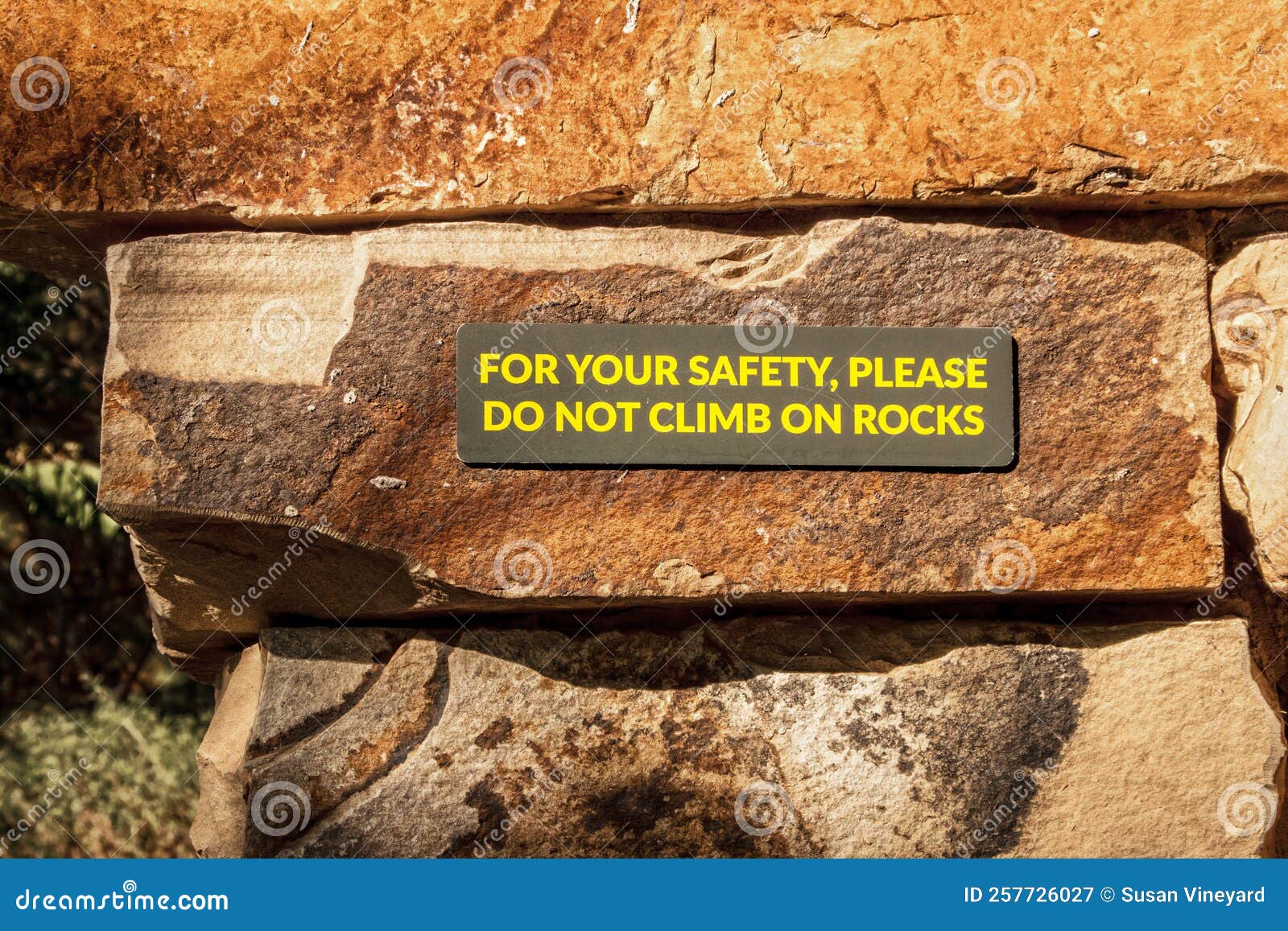 No Climbing Sign on Rustic Rock Wall Yellow Letters on Brown