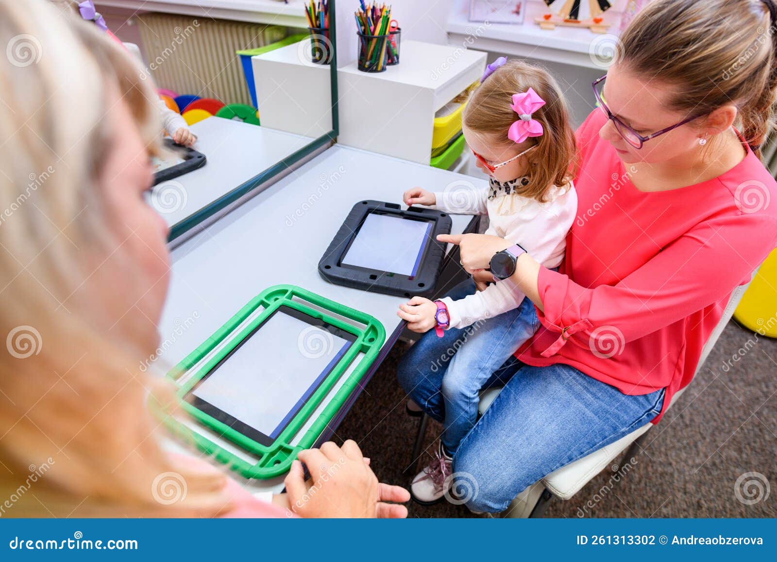 non-verbal girl living with cerebral palsy, learning to use digital tablet device to communicate.