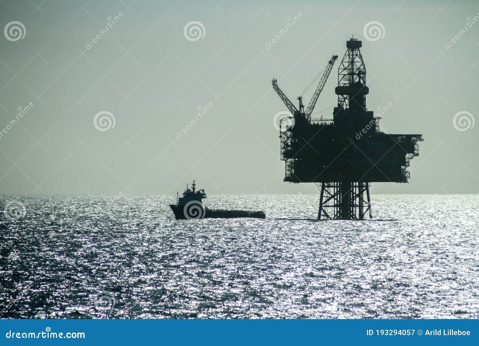 silhouette of an offshore supply vessel alongside oil platform ringhorn in the north sea