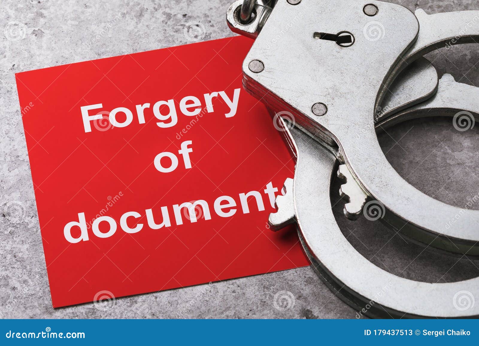 a note with text and handcuffs on the table, a major plan. concept on the punishment of forgery of documents