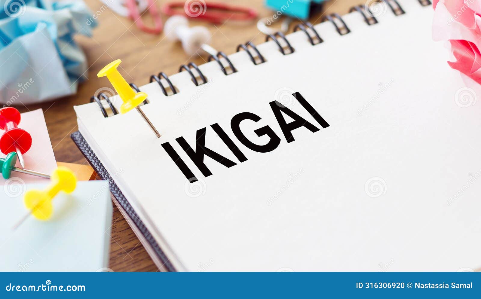 notebook featuring the word ikigai surrounded by colorful push pins and gifts