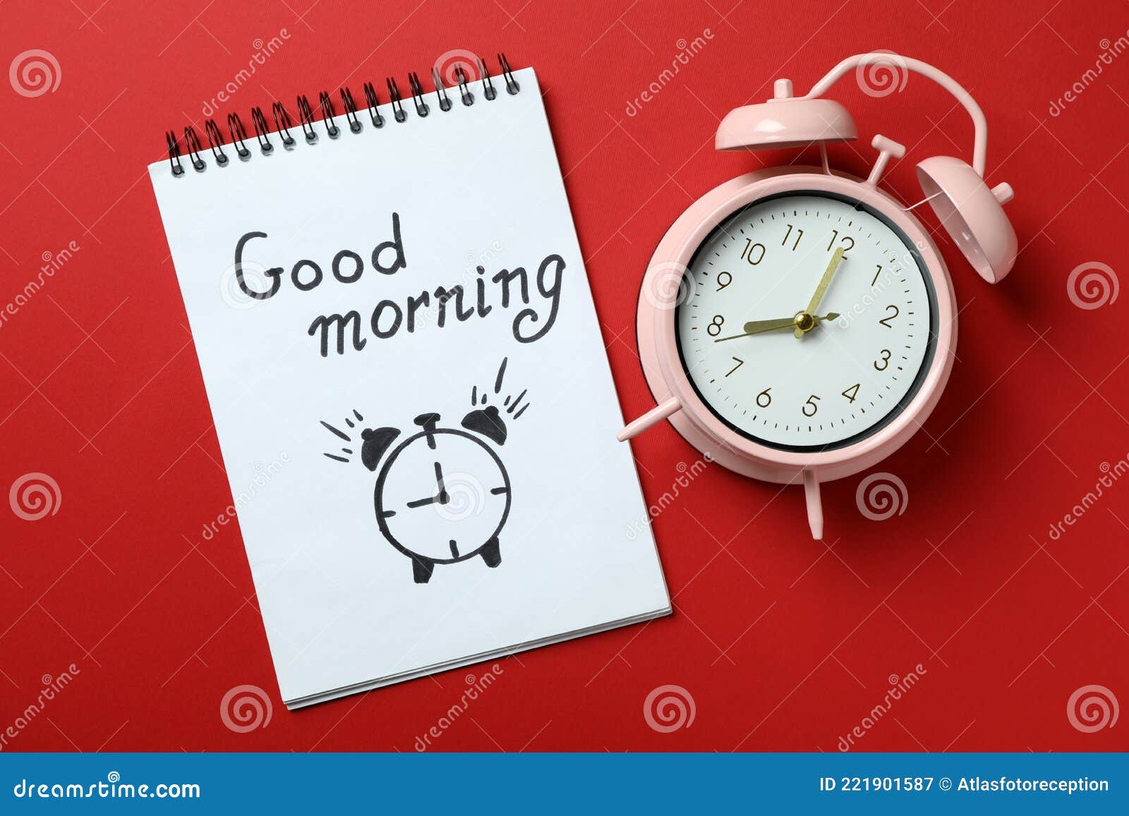Notebook with Good Morning and Alarm Clock on Red Background Stock