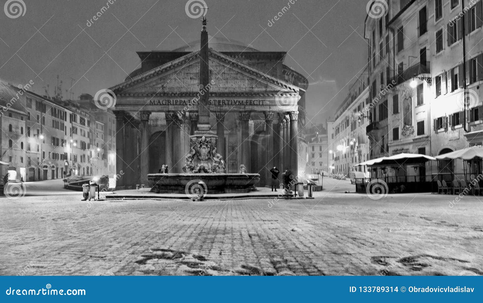 Notte di inverno a Roma con la chiesa della bufera di neve della neve e del tempio del panteon nel quadrato vuoto con luce dorata, bufera di neve dell'Italia