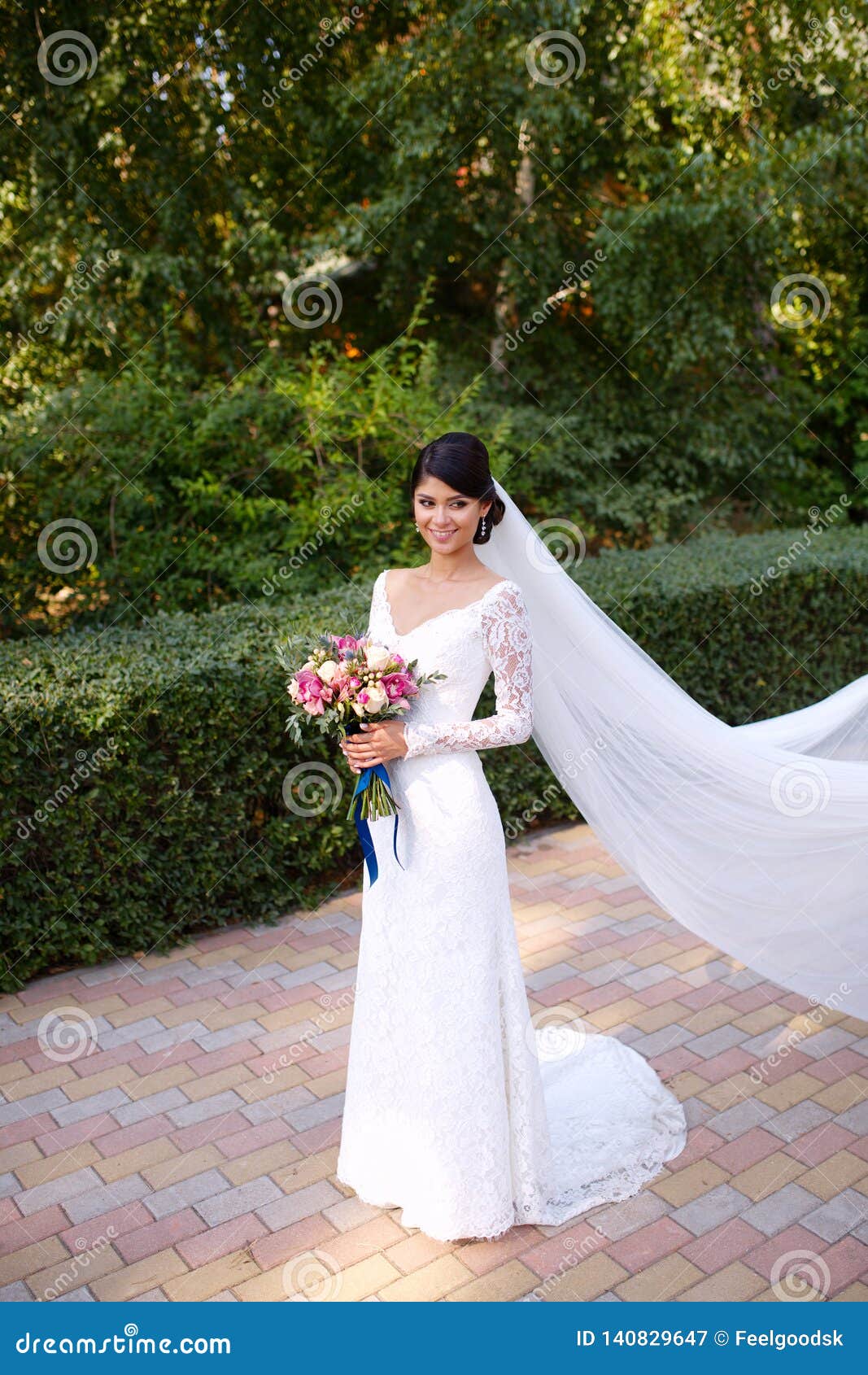 marxista Tantos Berri Novia Hermosa En Casarse El Vestido Blanco, Un Velo Largo En Su Pelo, Ramo  De Flores En Sus Manos Imagen de archivo - Imagen de creativo, lindo:  140829647