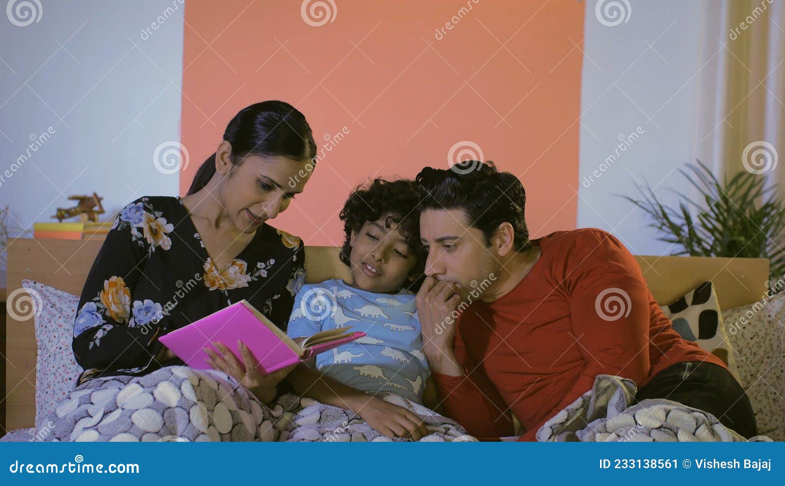 A Cheerful Indian Mother Telling a Bedtime Story To Her Adorable Child ...