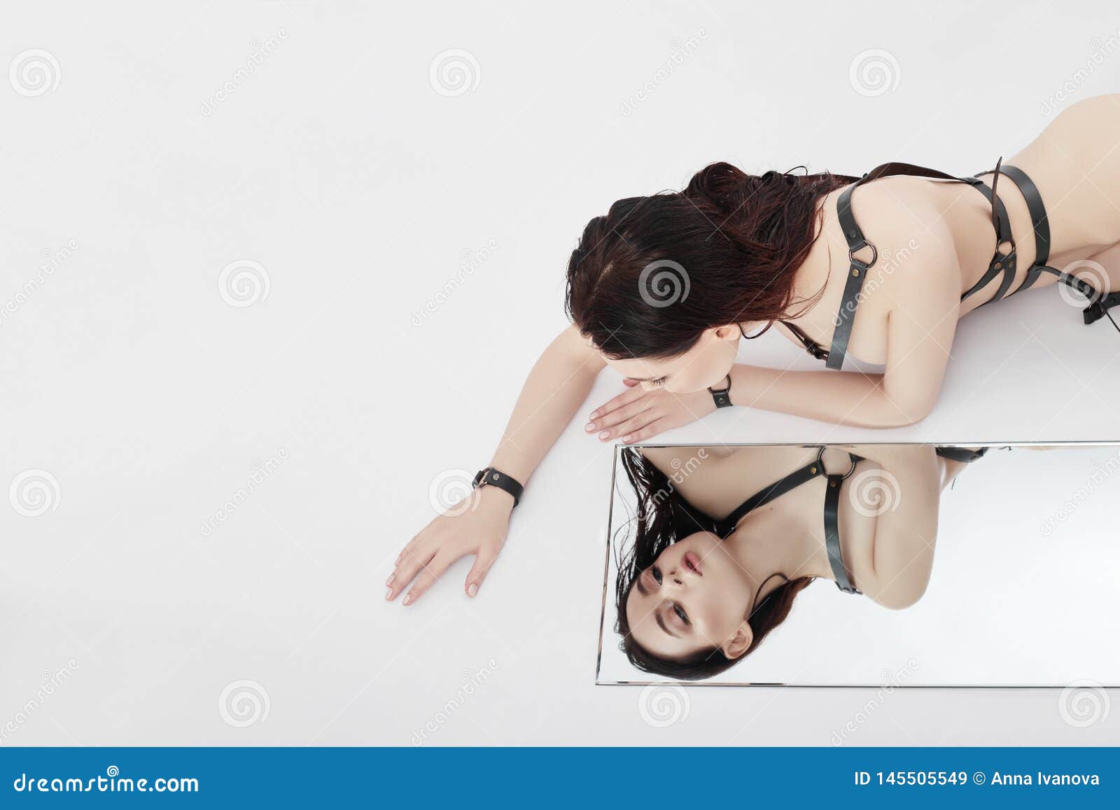 Nude Fashion Woman Lies on Mirror and Looks at Her Reflection