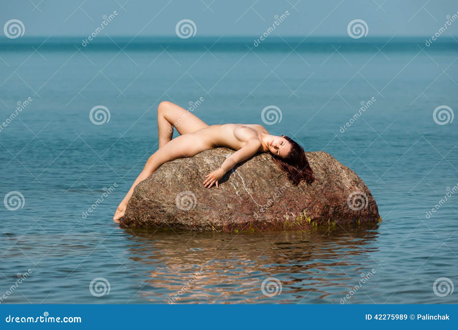 Nude Woman Lying on a Rock in the Sea Stock Image - Image of