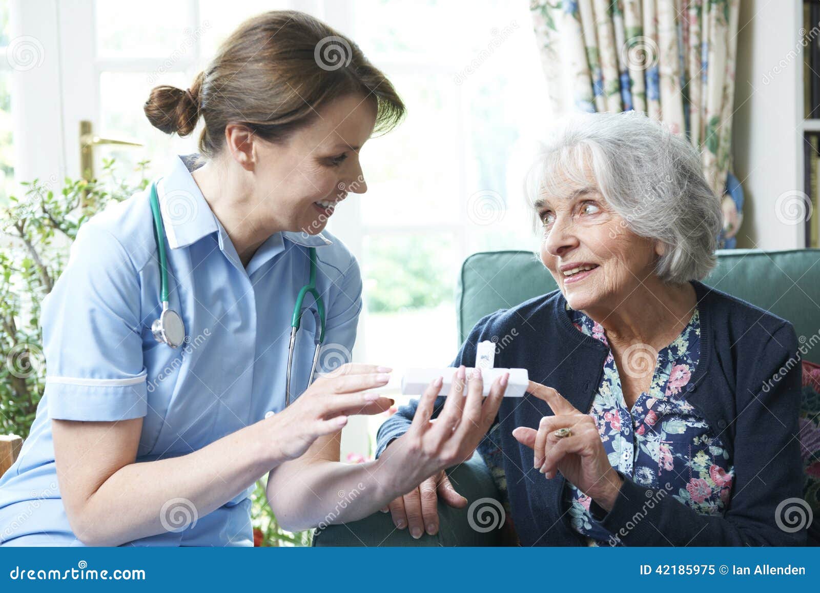 nurse advising senior woman on medication at home