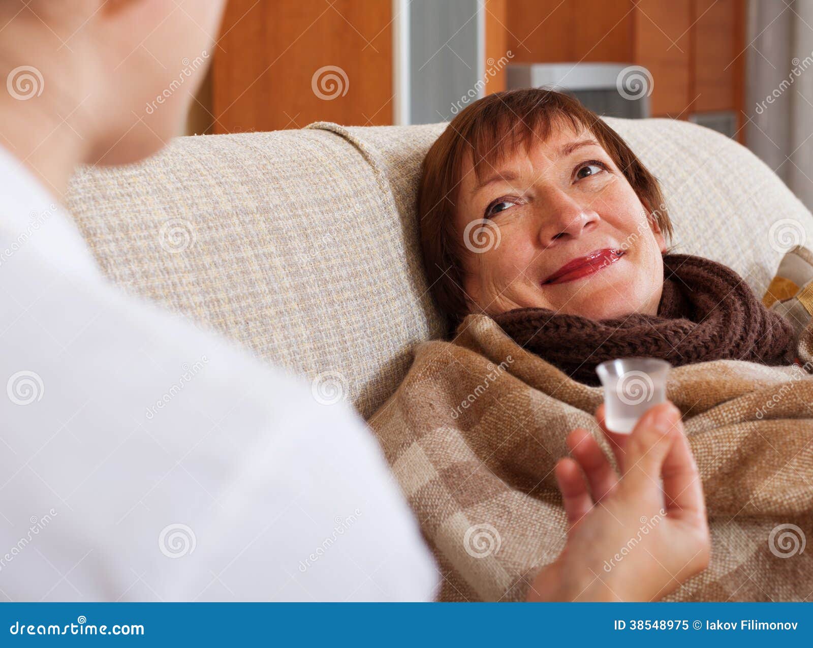 nurse caring for sick mature woman at home