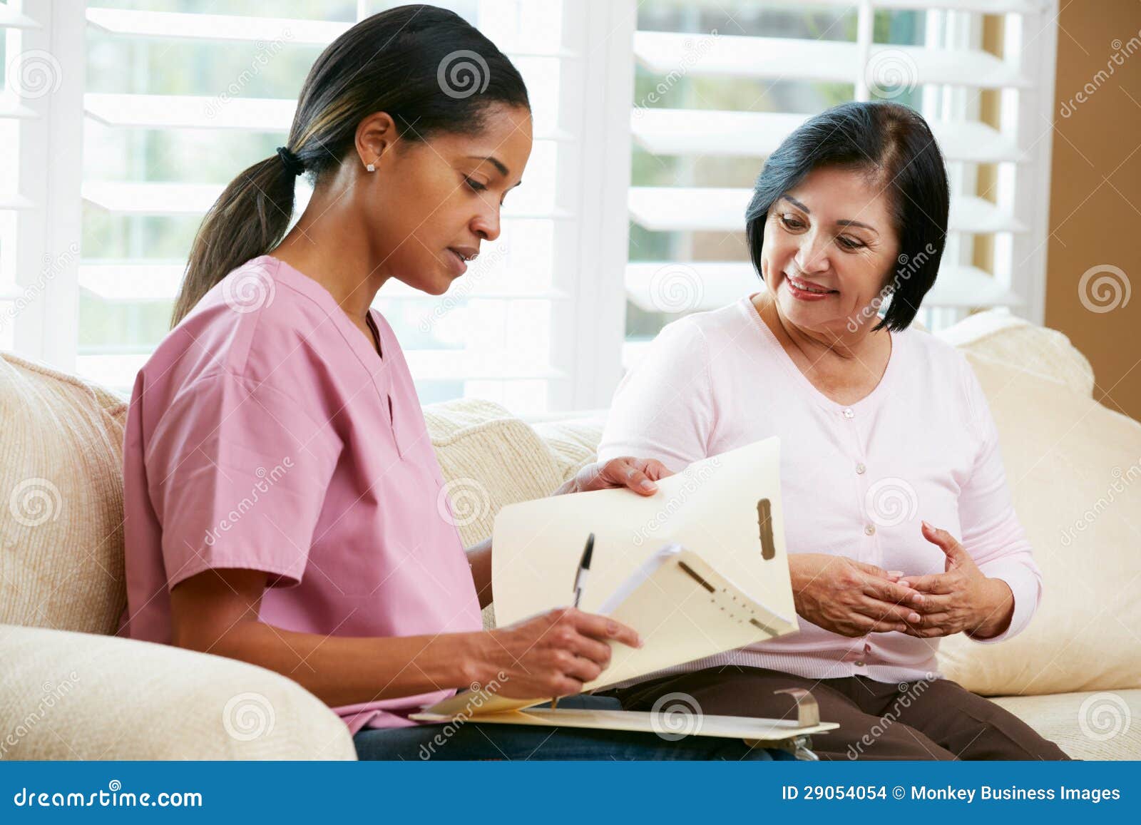 nurse discussing records with senior female patient