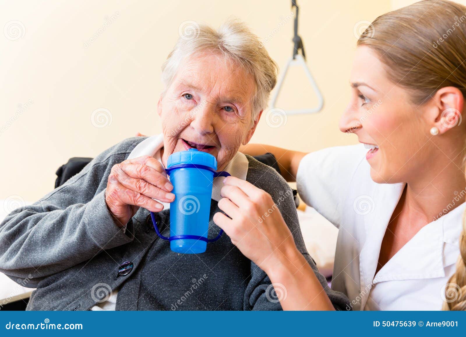 Nurse Giving Drink To Elderly Woman in Wheelchair Stock Image Image