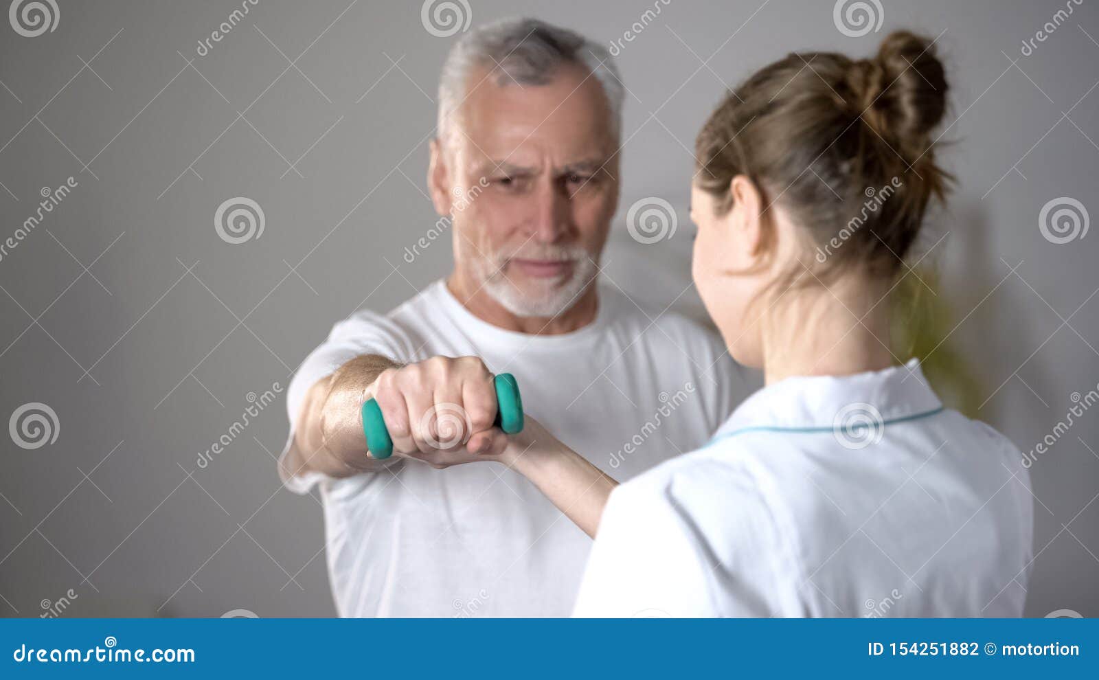 nurse helping old man to lift dumbbell, cardiac rehabilitation, injury recovery