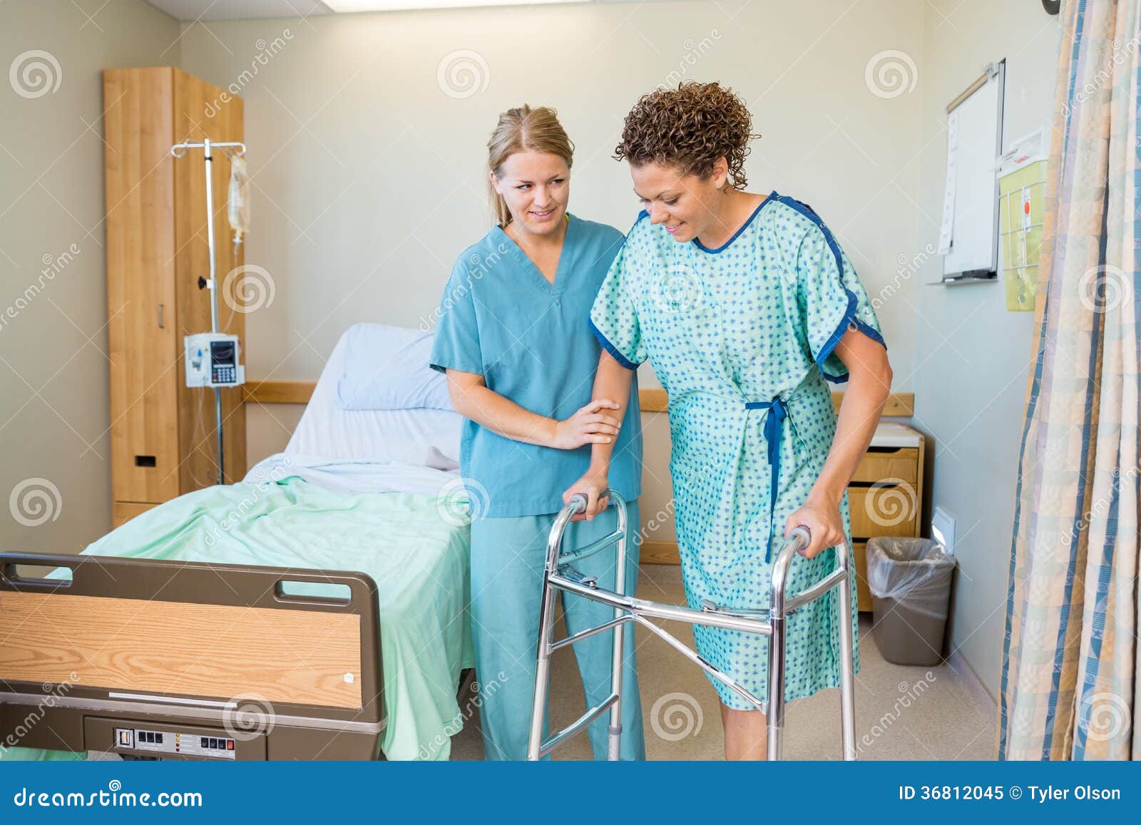 Mid adult female nurse helping patient to walk using walker in hospital