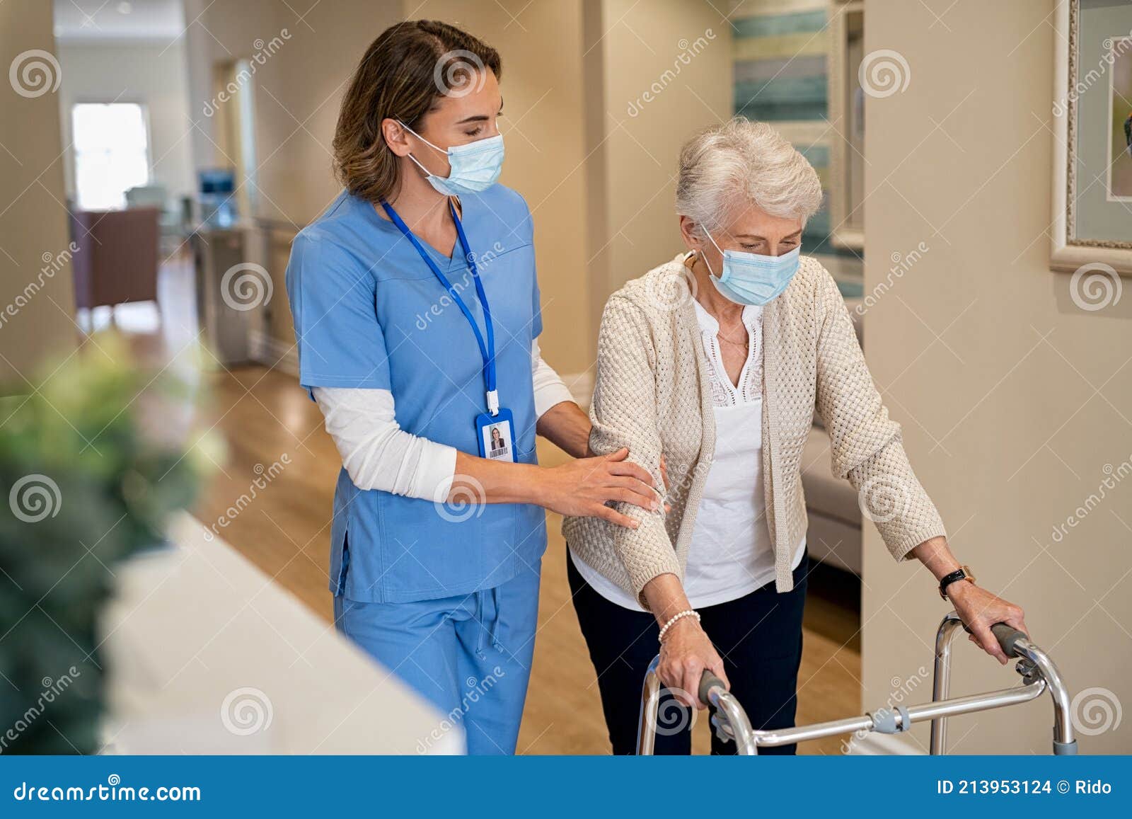 nurse helping senior woman walk at nursing home