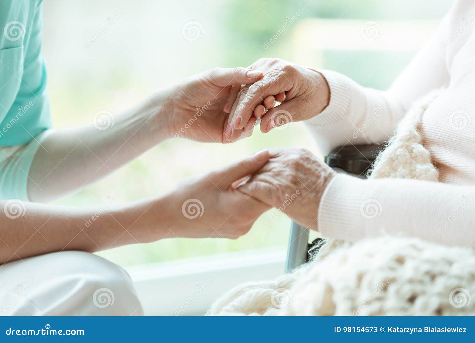 nurse holding patient`s hands