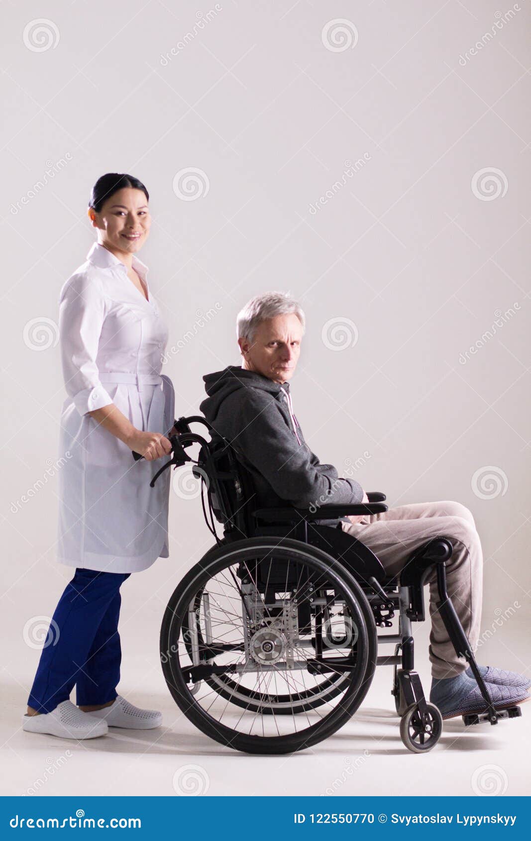 Nurse Pushing Wheelchair with Man in it. Stock Photo - Image of ...