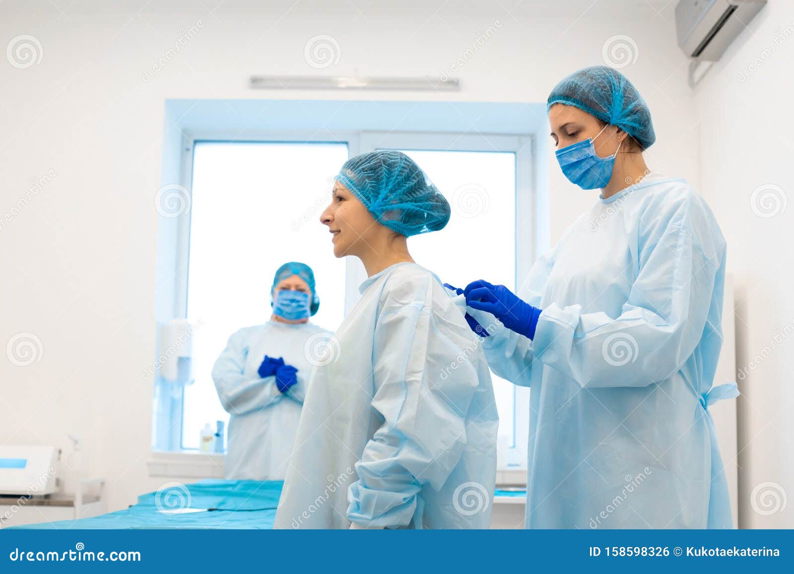 The Nurse Puts the Patient in a Sterile Gown for the Operation. Removal of Moles in a Private