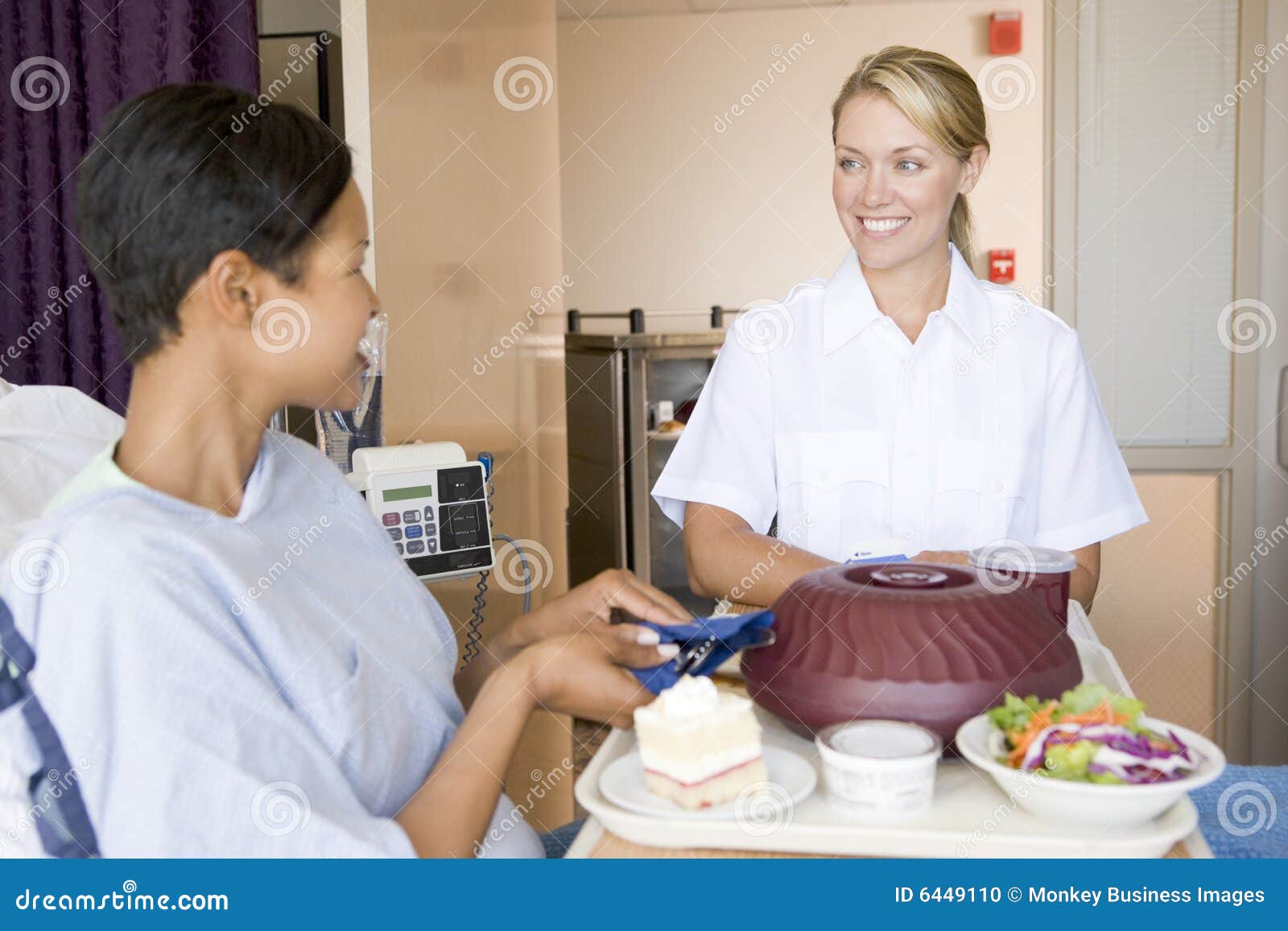 nurse serving a patient a meal in her bed