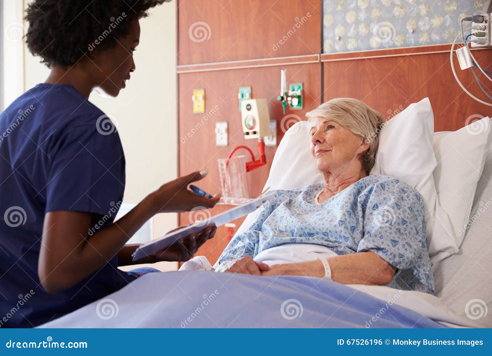 nurse talking to senior female patient in hospital bed