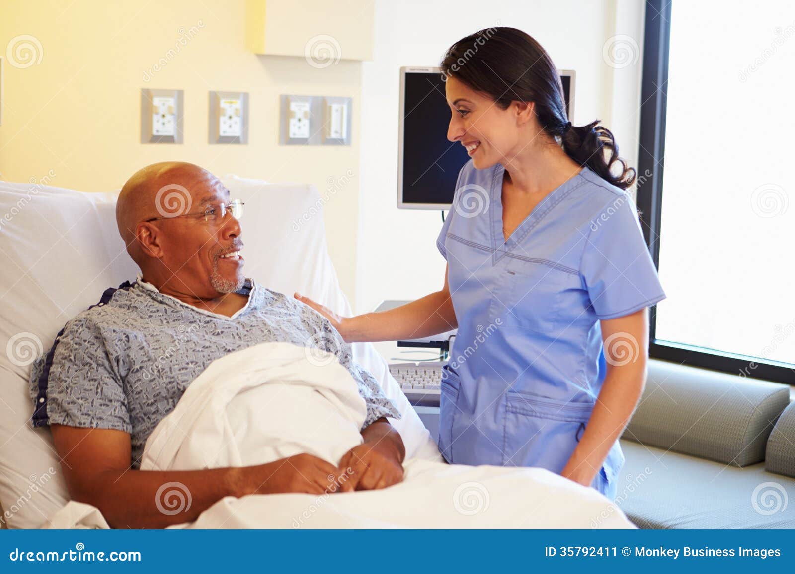 nurse talking to senior male patient in hospital room