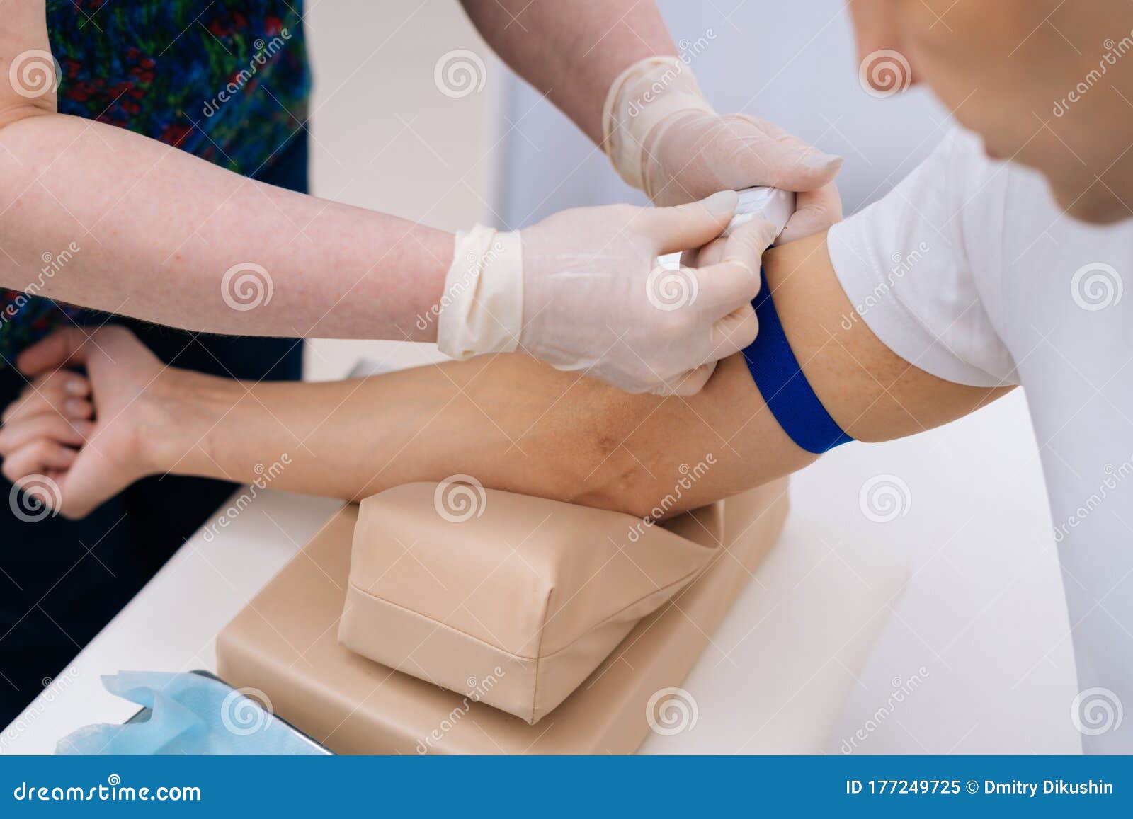 A Phlebotomist Technician Drawing Blood From Arm Of A Patient With