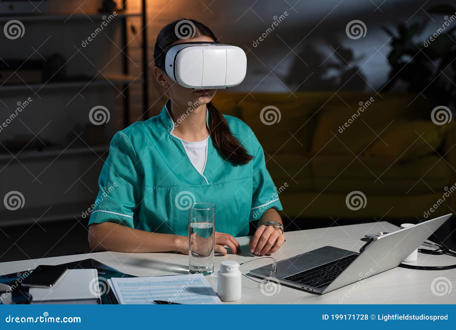 Nurse in Uniform with Virtual Reality Headset Sitting at Table Stock
