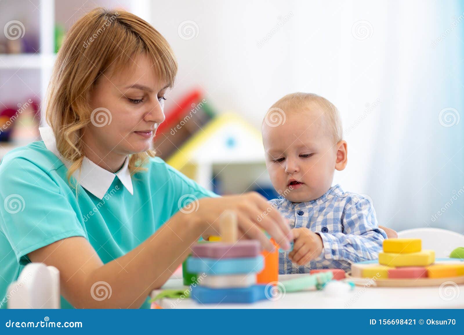 nursery baby playing with teacher in the classroom stock teacher toddler