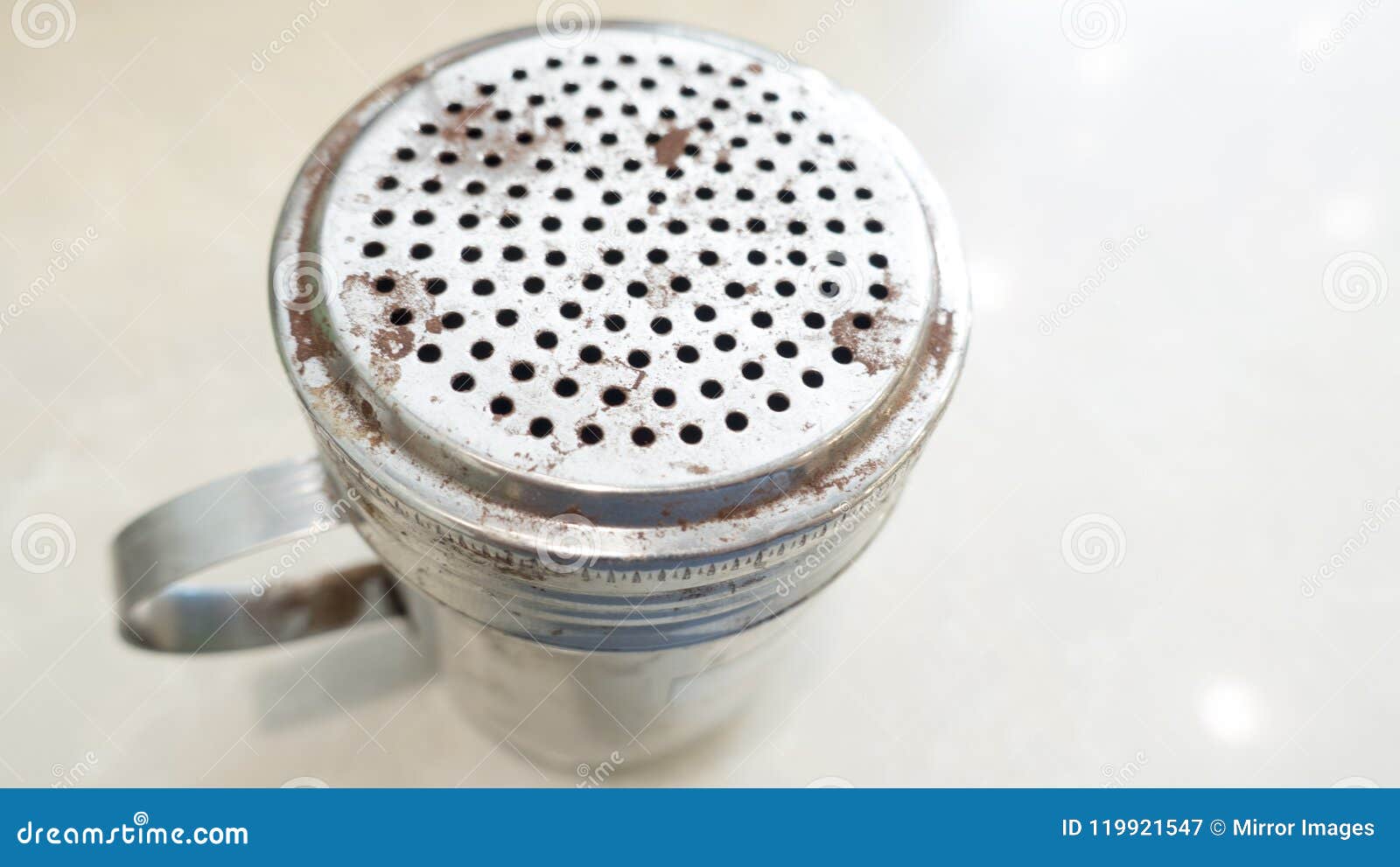cinnamon or chocolate shaker. top view, messy, used, dinged, high use, old, classic,