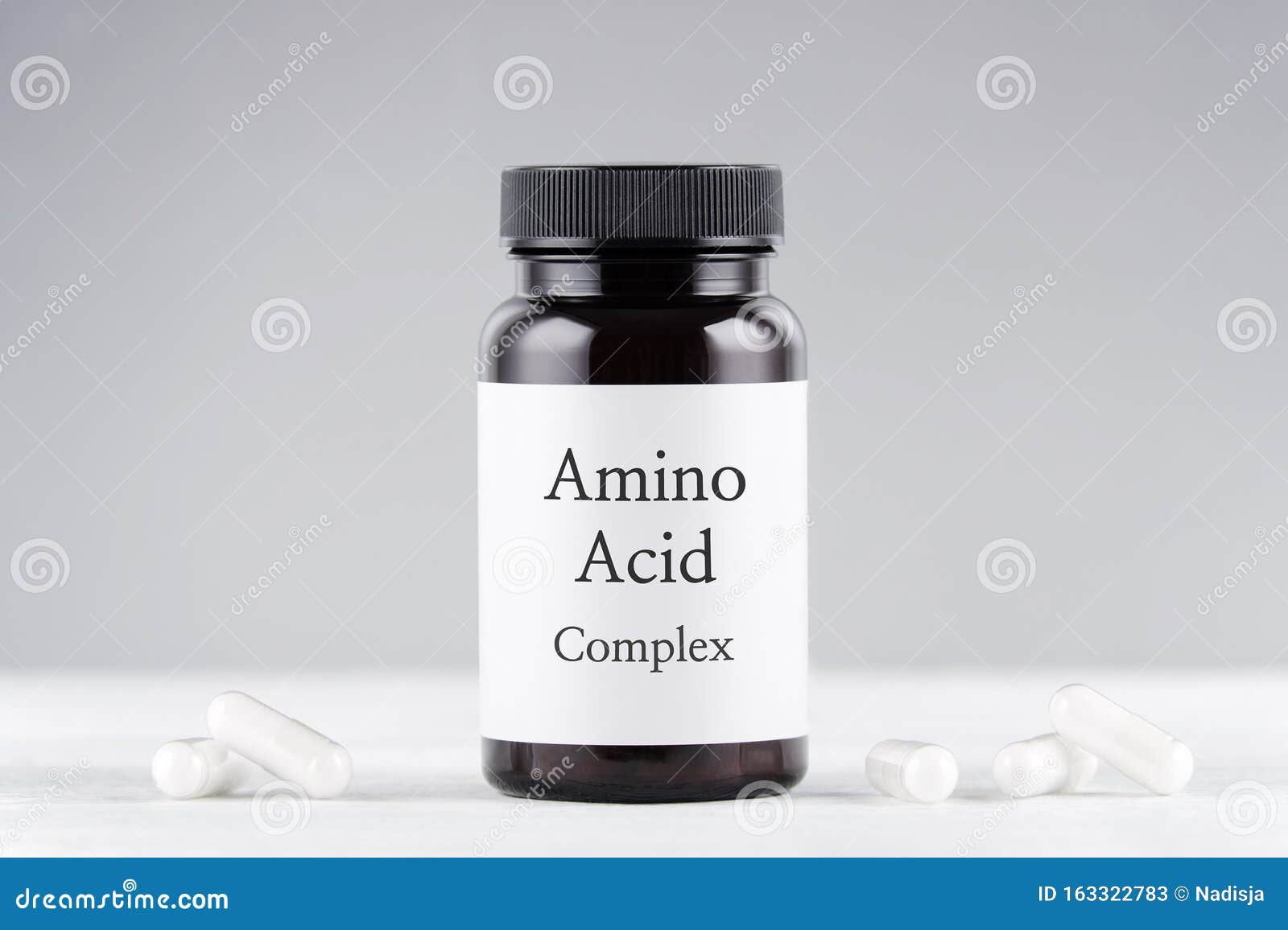 Nutritional Supplement Amino Acids Bottle and Capsules on Gray Stock