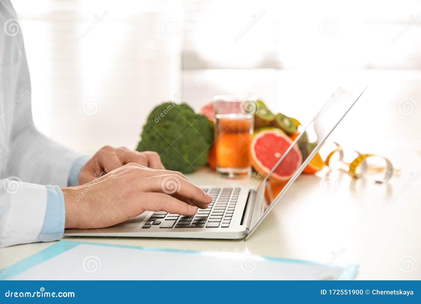 nutritionist working with laptop at desk in office