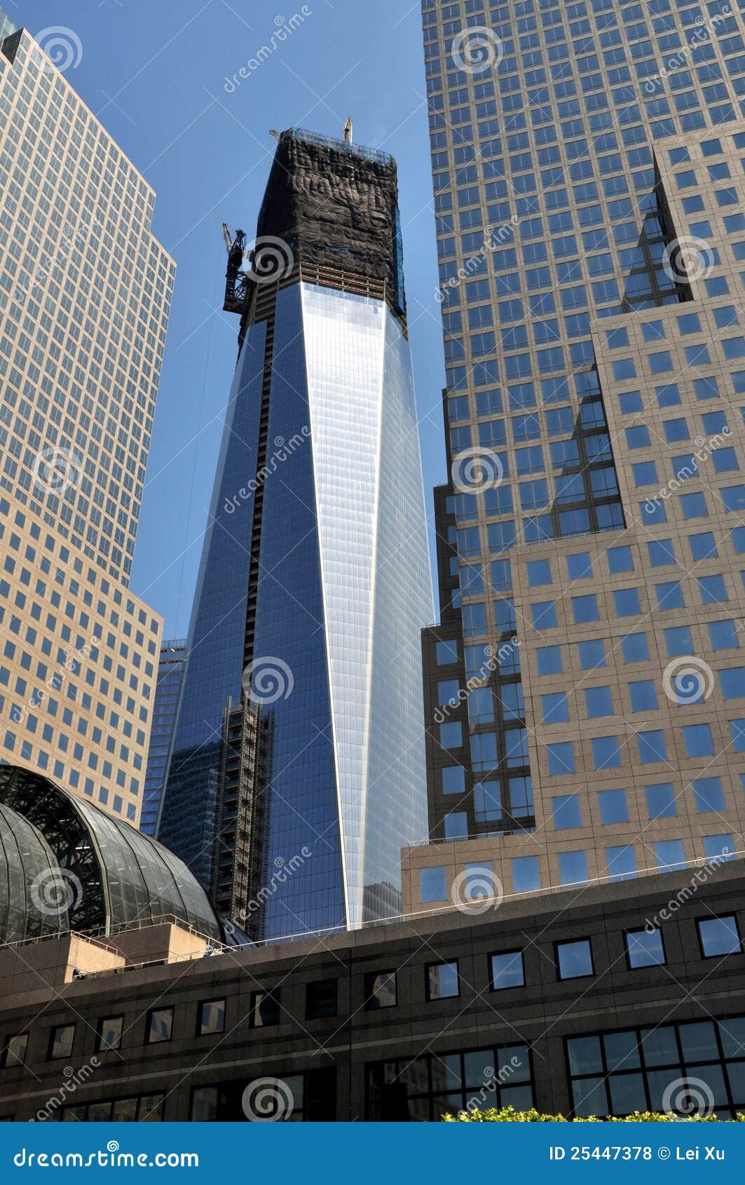 NYC: Uma torre do World Trade Center. Um World Trade Center (a torre da liberdade) como ela aproxima a conclusão vista entre as torres do centro financeiro de mundo no ponto zero em New York City.