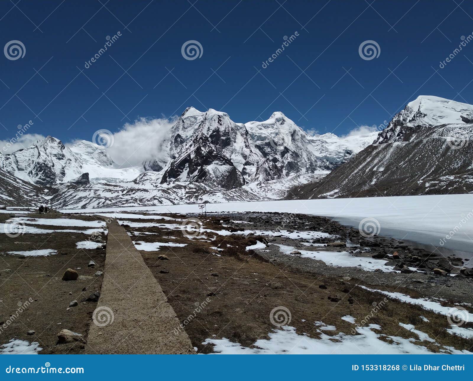 Nå det härliga berget, längs sidan av djupfryst llake. Nå det snöig berget, under den blåa himlen, längs sidan av den djupfrysta sjön Lopp till berget som lokaliseras i norr Sikkim, Indien