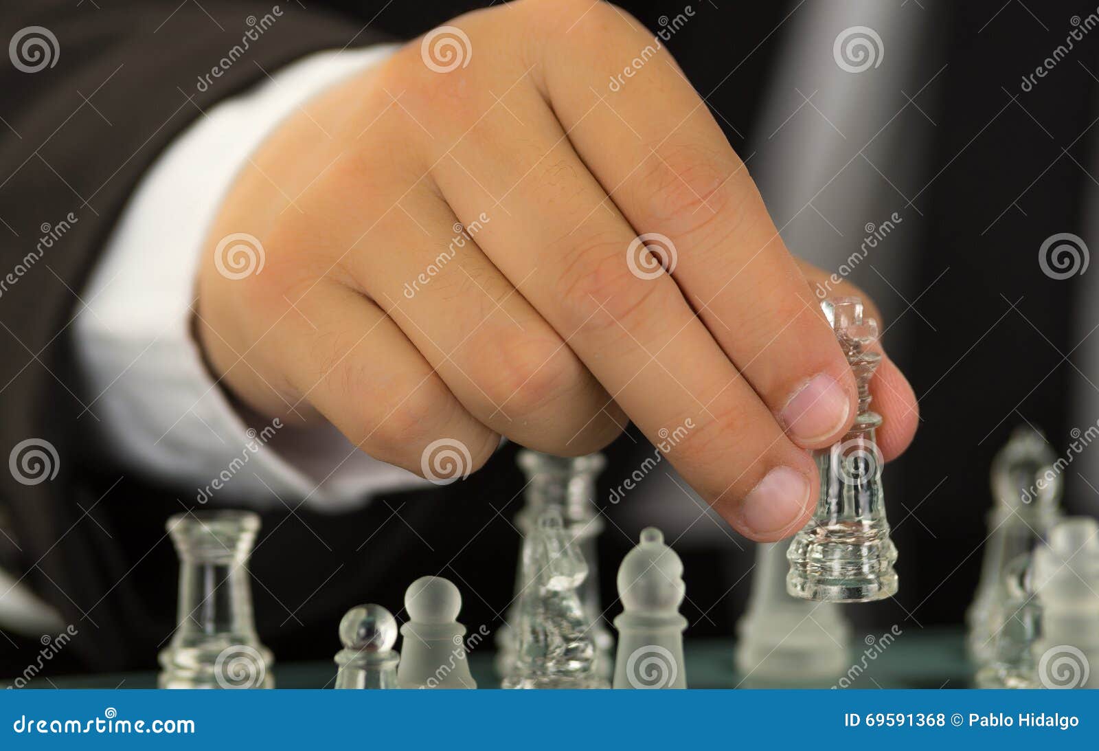 Mão Do Homem De Negócios Jogando Xadrez. Mão Do Homem De Negócios Segurando  A Peça Da Rainha Do Xadrez Sobre O Tabuleiro De Xadrez. Estratégia De  Negócios Para A Vitória. Foto Royalty