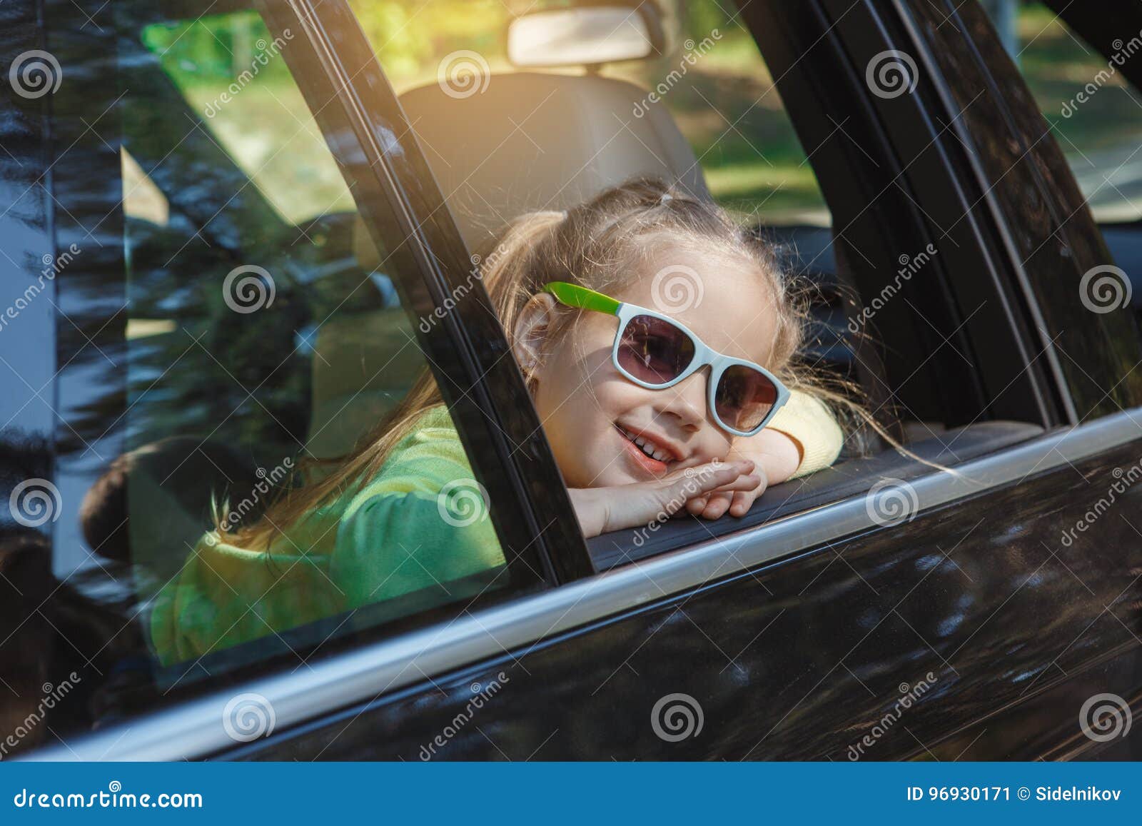 O curso pela viagem da família do carro vacation junto. Curso do carro da família do passeio por óculos de sol vestindo da menina junto