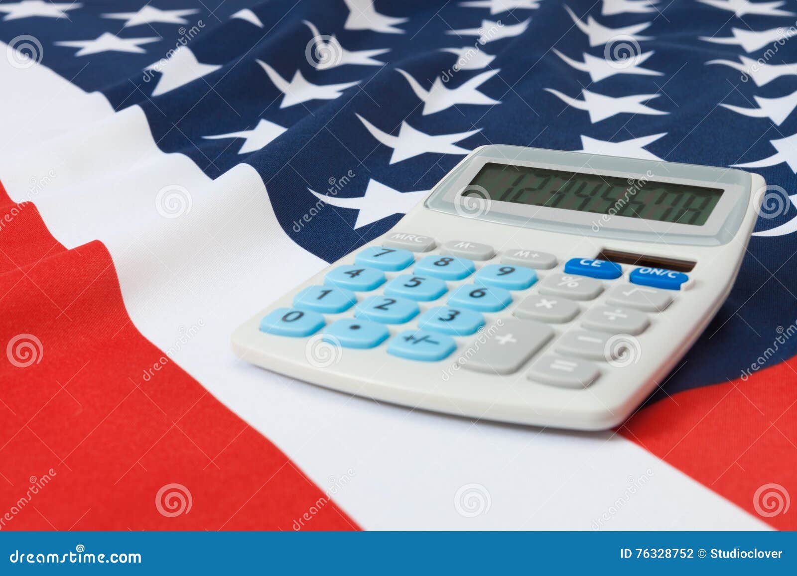 O estúdio disparou da bandeira nacional enrugado com a calculadora sobre ele - no Estados Unidos da América. Parte da bandeira nacional enrugado do tiro do estúdio com a calculadora sobre ela série - Estados Unidos da América