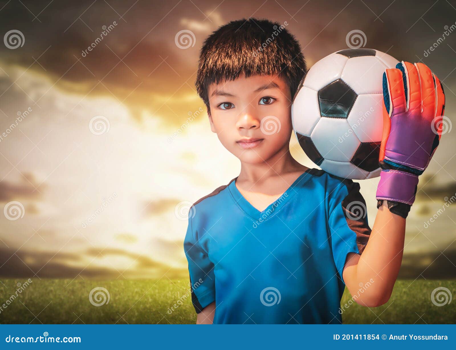 Um garoto segurando a velha bola de futebol antes de começar um jogo de  futebol