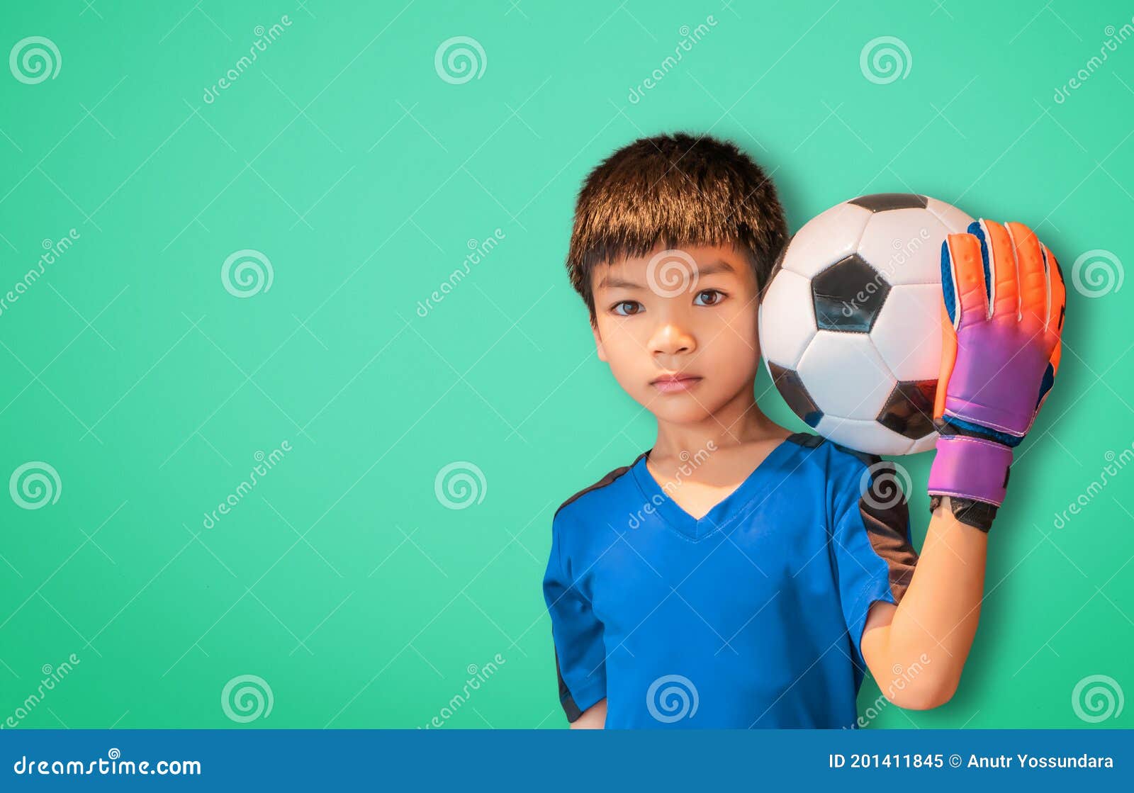 Um garoto segurando a velha bola de futebol antes de começar um jogo de  futebol