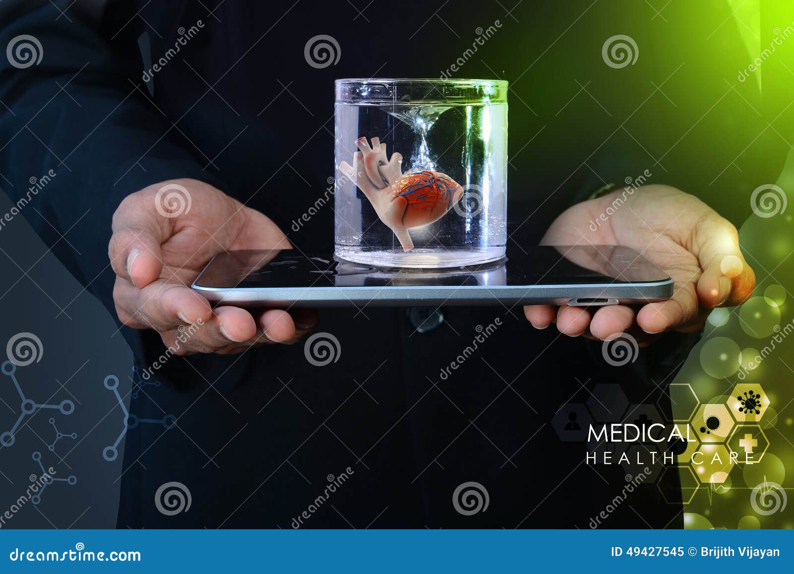 O homem está guardando um coração no vidro da água e do tablet pc no fundo da cor