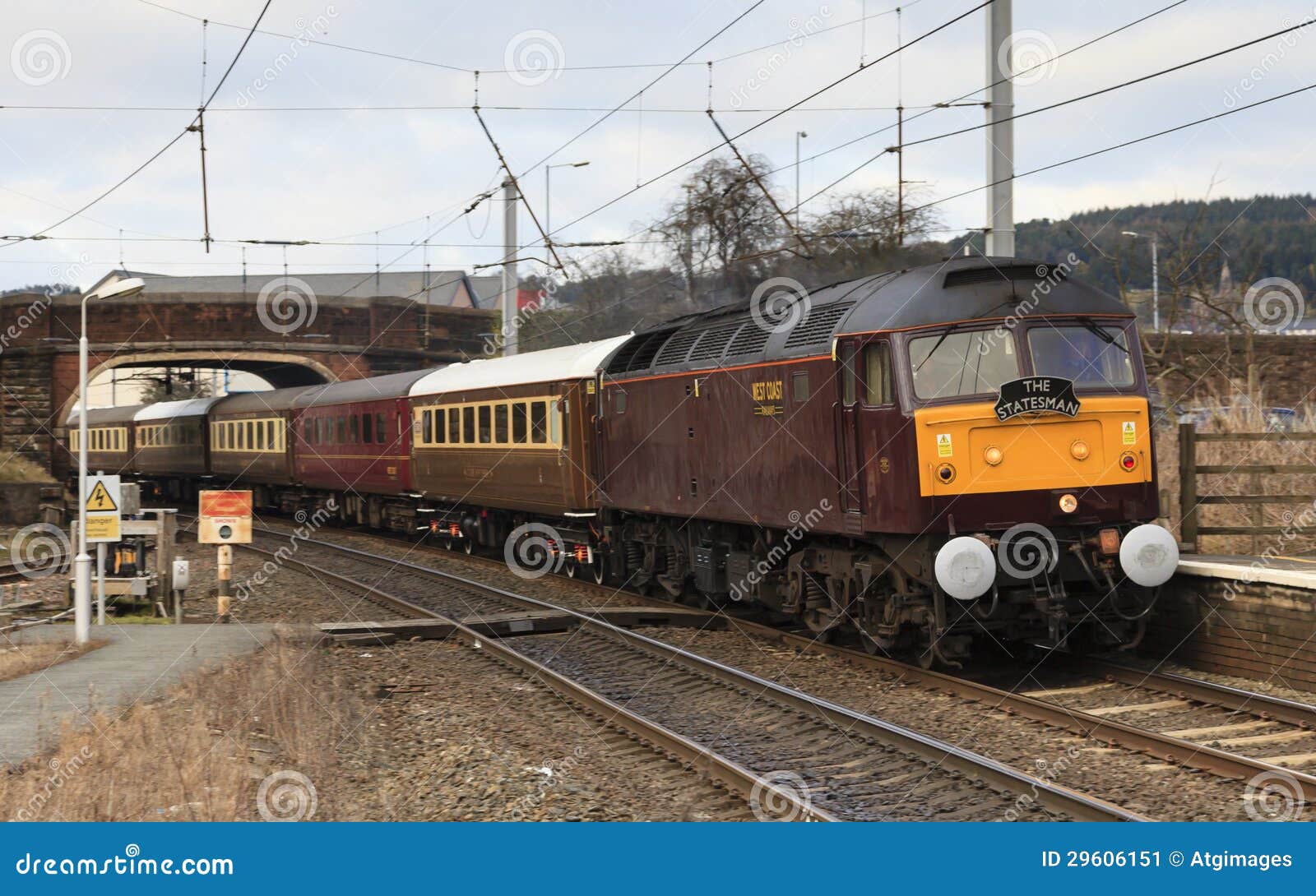 Uma locomotiva diesel da classe 47 dirige a estação direta southbound de Penrith do homem político em Cumbria o 2 de março de 2013, no mainline da costa oeste.