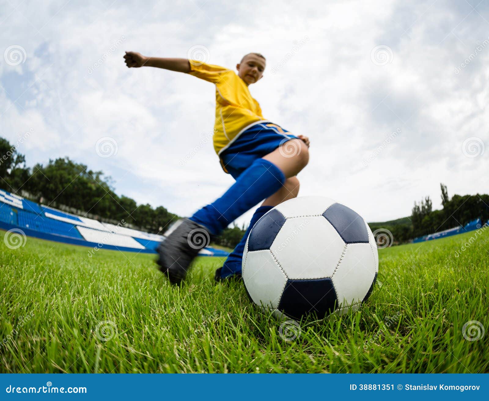 Um garoto segurando a velha bola de futebol antes de começar um jogo de  futebol