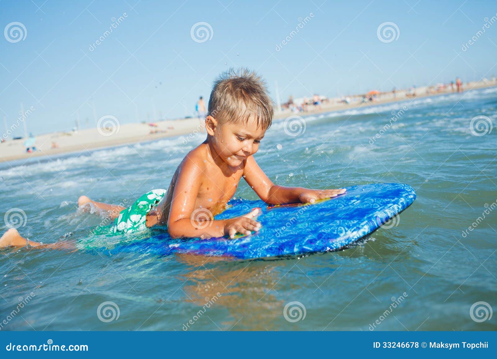 O menino tem o divertimento com a prancha. O menino tem o divertimento na prancha no mar da transparência