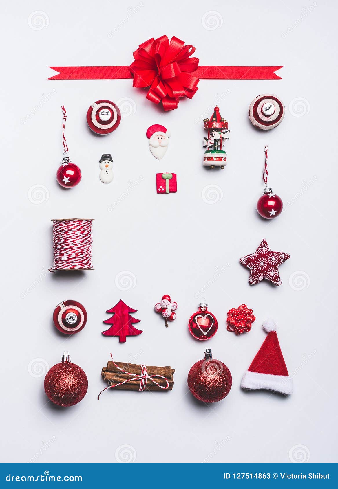 O Natal ornaments a composição do quadro da configuração do plano no fundo branco, vista superior Decoração e papel de embrulho v. O Natal ornaments a composição do quadro da configuração do plano no fundo branco, vista superior Objetos vermelhos da decoração e do papel de embrulho e do pacote do Natal, disposição mínima festiva