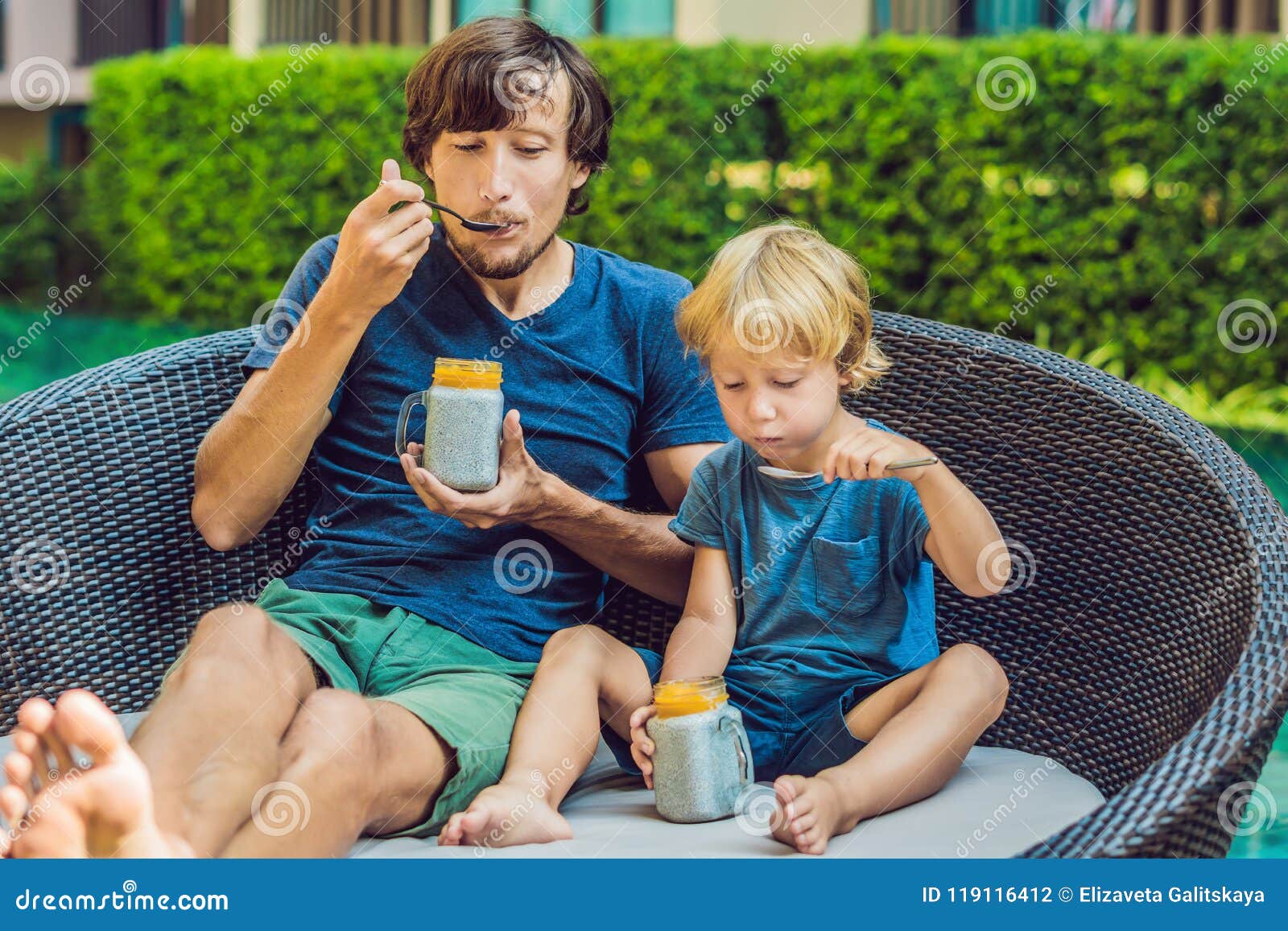 Pai e filho comem sobremesa com sementes de chia e mangas à beira