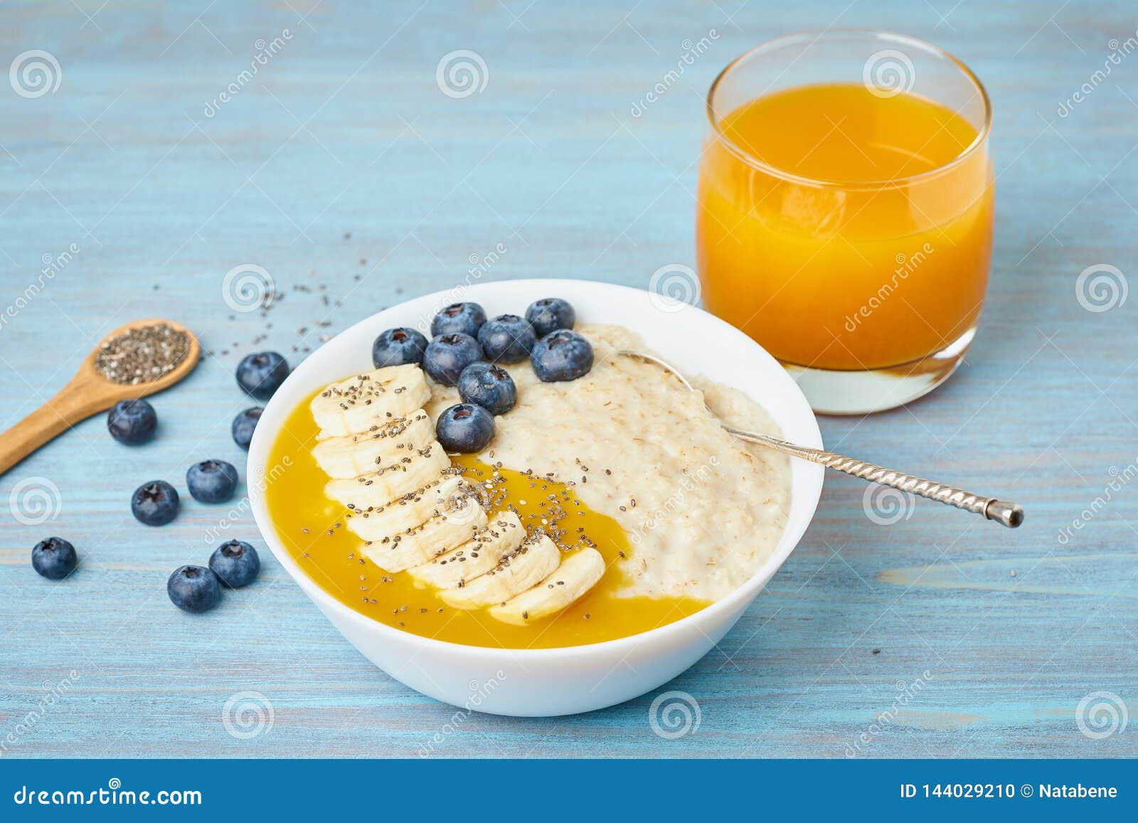 Oatmeal with Bananas, Blueberries, Chia Seeds, Jam on Blue Wooden ...