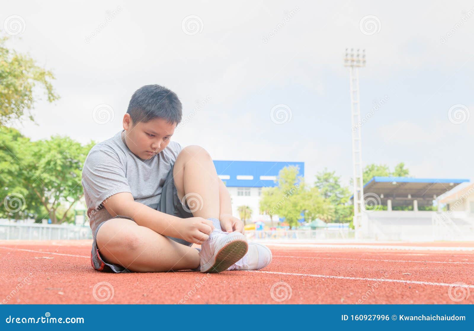 Obese Boy Tying Shoe Laces Prepare To 