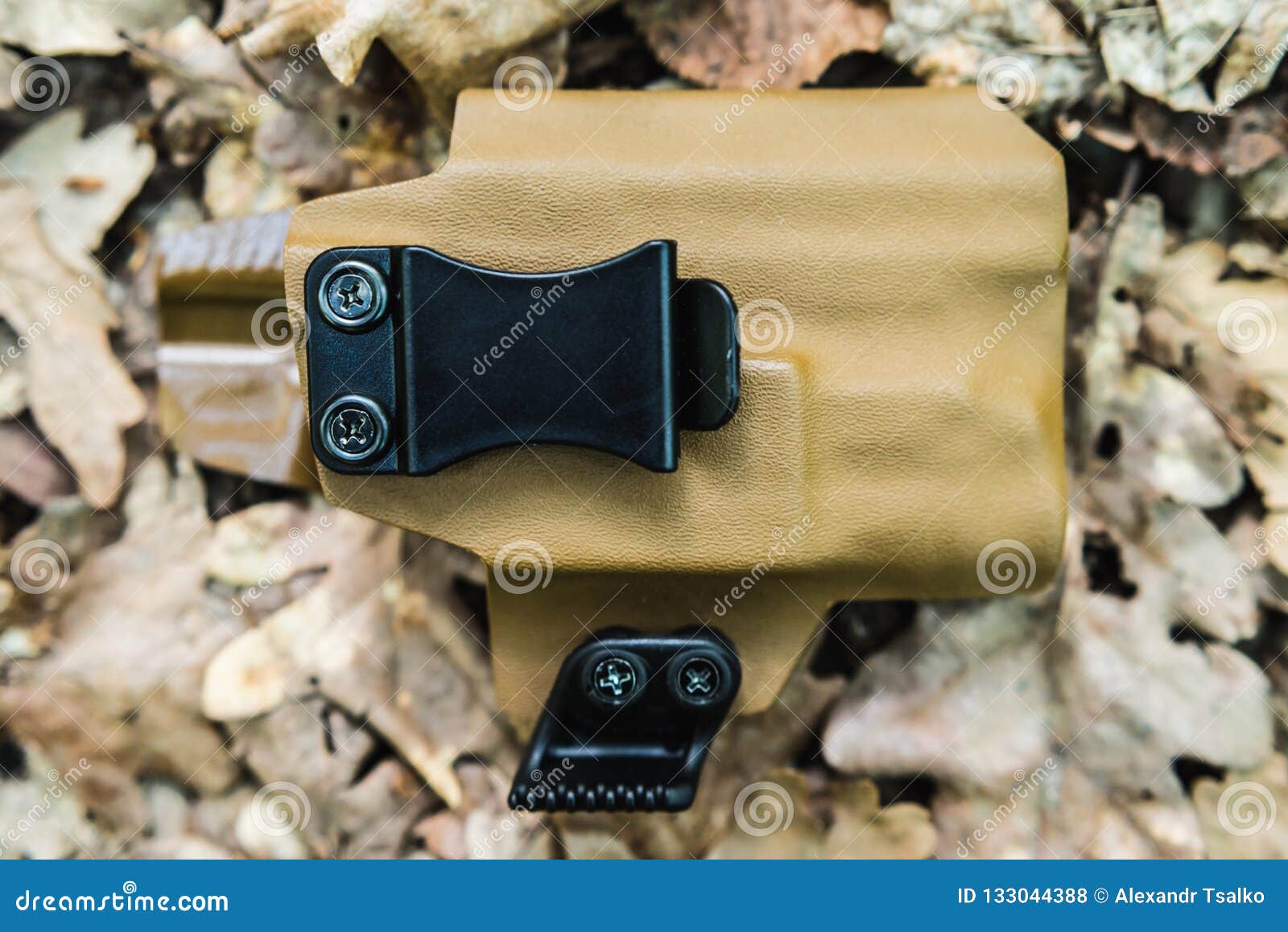 objective holster shooting on dry leaves in the forest